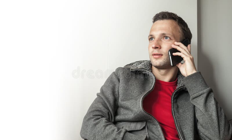 Portret młody dorosły Kaukaski mężczyzna opowiada na telefonie komórkowym obrazy royalty free Portret młody dorosły Kaukaski mężczyzna opowiada na telefonie komórkowym obrazy royalty free