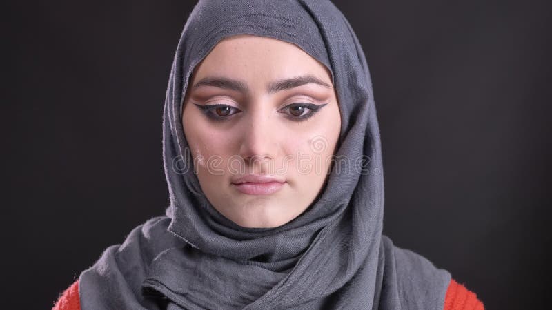 Portret piękna muzułmańska kobieta w hijab z jaskrawym i błyszczącym makijażem podnosi ona i ogląda spokojnie w kamerę oczy