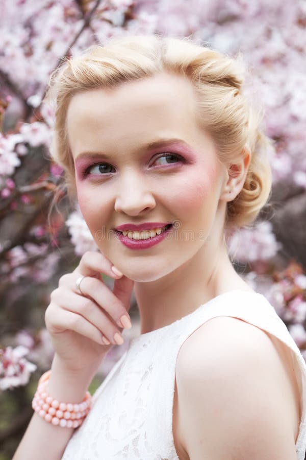 Portret piękna młoda blond kobieta na tle różowi czereśniowi okwitnięcia w wiośnie obrazy stock Portret piękna młoda blond kobieta na tle różowi czereśniowi okwitnięcia w wiośnie obrazy stock