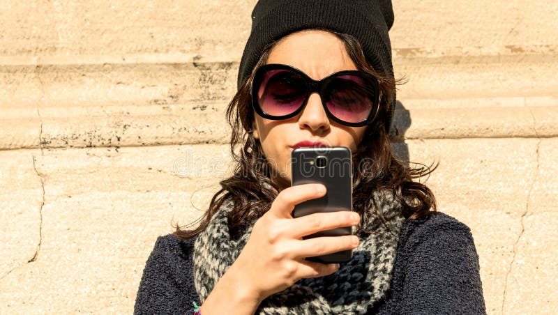 Portret piękna nastoletnia dziewczyna patrzeje jej smartphone - grże filtr obrazy stock Portret piękna nastoletnia dziewczyna patrzeje jej smartphone - grże filtr obrazy stock