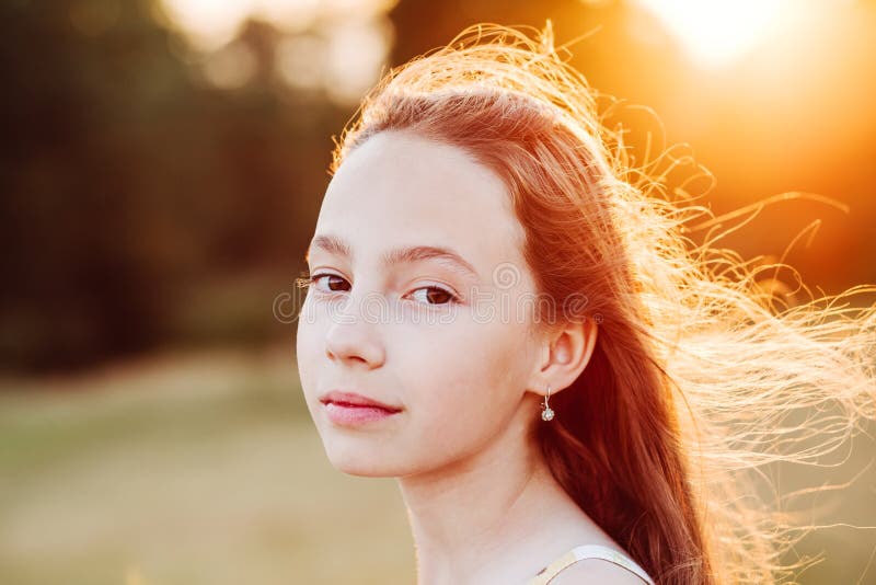 Portret Piękna poważna Nastoletnia dziewczyna cieszy się naturę w parku przy lato zmierzchem obraz royalty free Portret Piękna poważna Nastoletnia dziewczyna cieszy się naturę w parku przy lato zmierzchem obraz royalty free