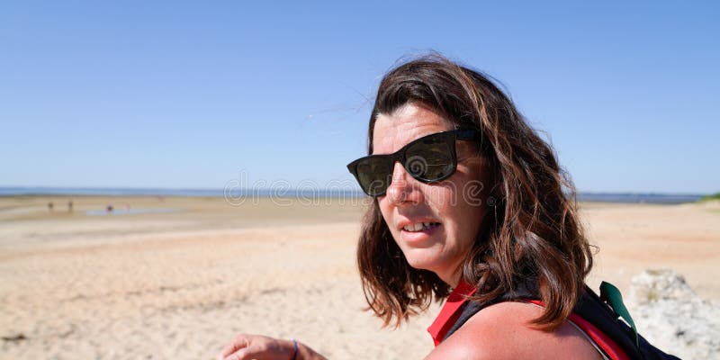 Portret pięknej brunetki w wieku 40 lat w średnim wieku na letniej wycieczce na plaży piaskowej obrazy stock