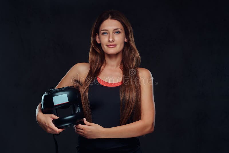 Portret pięknej brunetki żeński bokser w sportswear trzyma ochronnego hełm, patrzeje kamerę Na zdjęcia royalty free Portret pięknej brunetki żeński bokser w sportswear trzyma ochronnego hełm, patrzeje kamerę Na zdjęcia royalty free