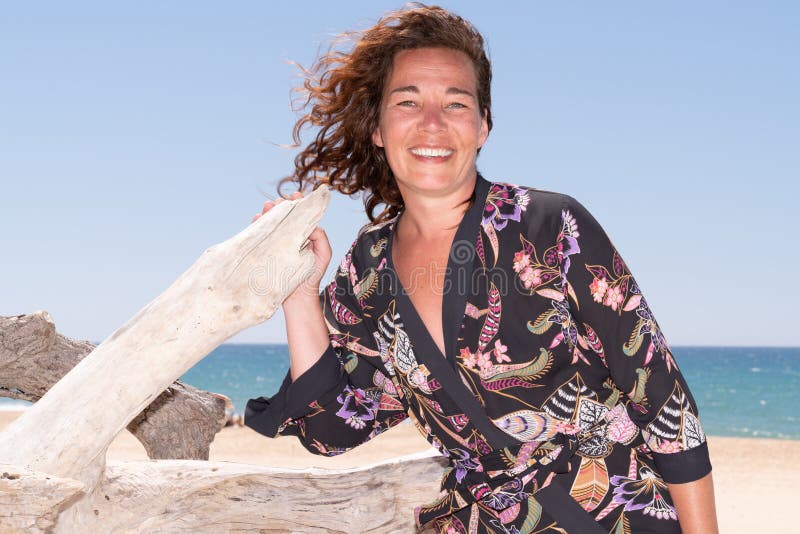 Portret piÄ™knej 40-letniej brunetki na plaży z dachówkÄ… zdjęcia stock
