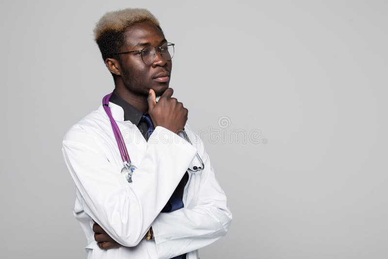 Portret przystojna zadumana Afro amerykanina lekarka utrzymuje rękę na jego podbródku i główkowaniu w białym żakiecie, patrzejący zdjęcia stock Portret przystojna zadumana Afro amerykanina lekarka utrzymuje rękę na jego podbródku i główkowaniu w białym żakiecie, patrzejący zdjęcia stock