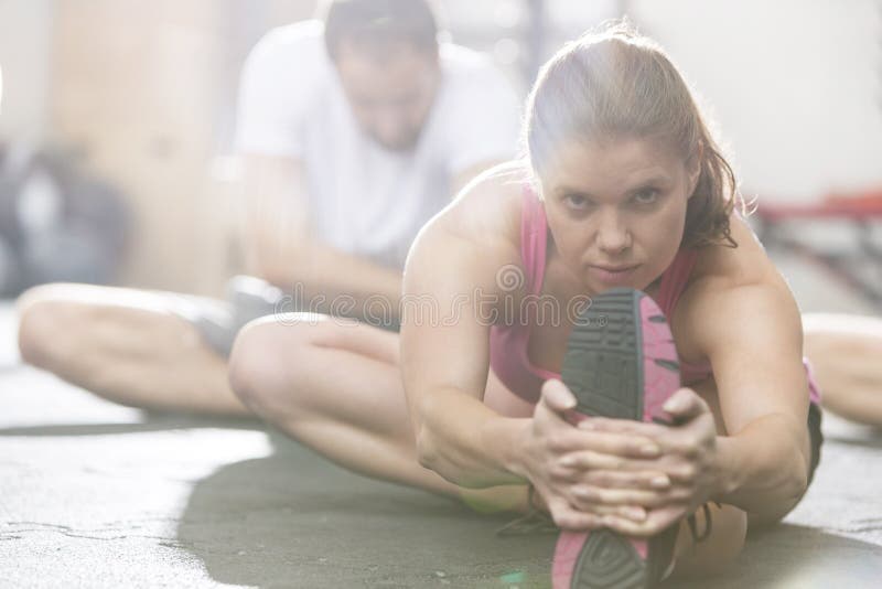 Portret robi rozciągania ćwiczeniu w crossfit gym ufna kobieta zdjęcia stock Portret robi rozciągania ćwiczeniu w crossfit gym ufna kobieta zdjęcia stock