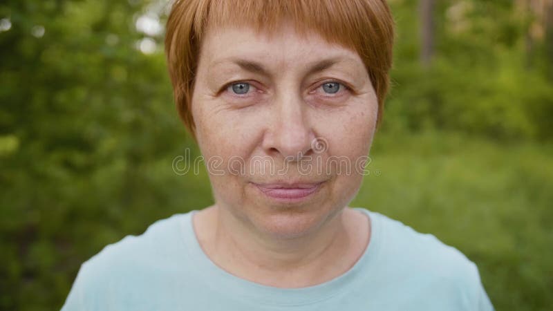 Portret starsza kobieta na zielonym tle w ogródzie