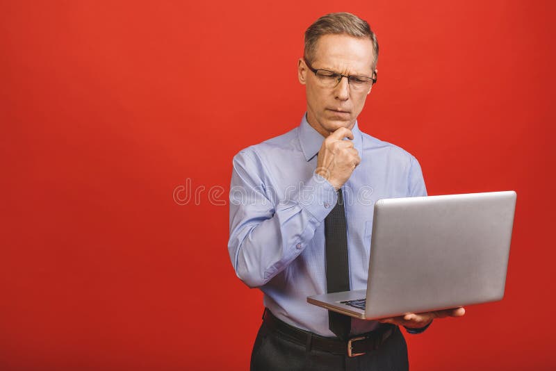Portret szczęśliwego starszego biznesmena trzymającego notebooka na czerwonym tle zdjęcia royalty free