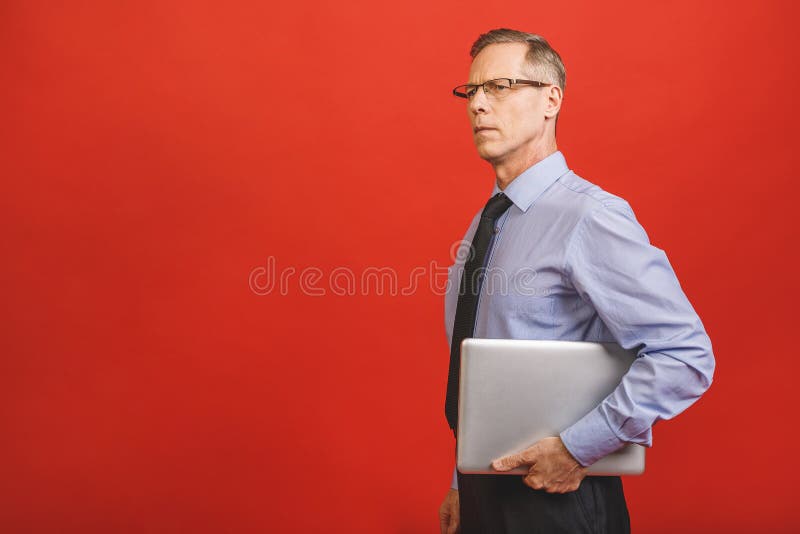 Portret szczęśliwego starszego biznesmena trzymającego notebooka na czerwonym tle fotografia royalty free