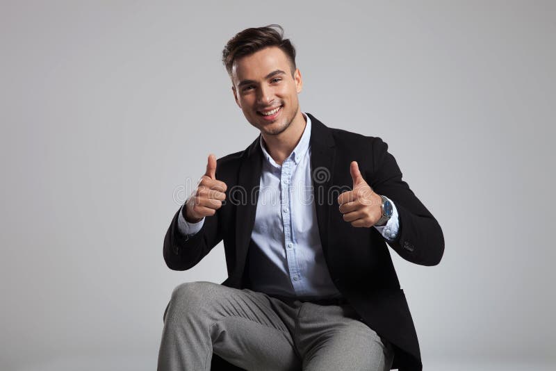 Portret szczęśliwy przypadkowy mężczyzna robi ok znakowi podczas gdy siedzący fotografia stock Portret szczęśliwy przypadkowy mężczyzna robi ok znakowi podczas gdy siedzący fotografia stock