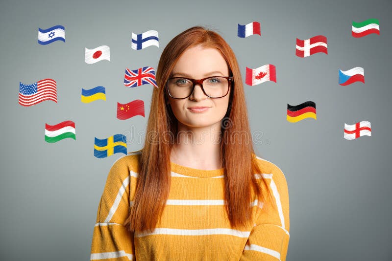 Portret tłumacza ustnego i flag różnych krajów na szarym tle fotografia royalty free