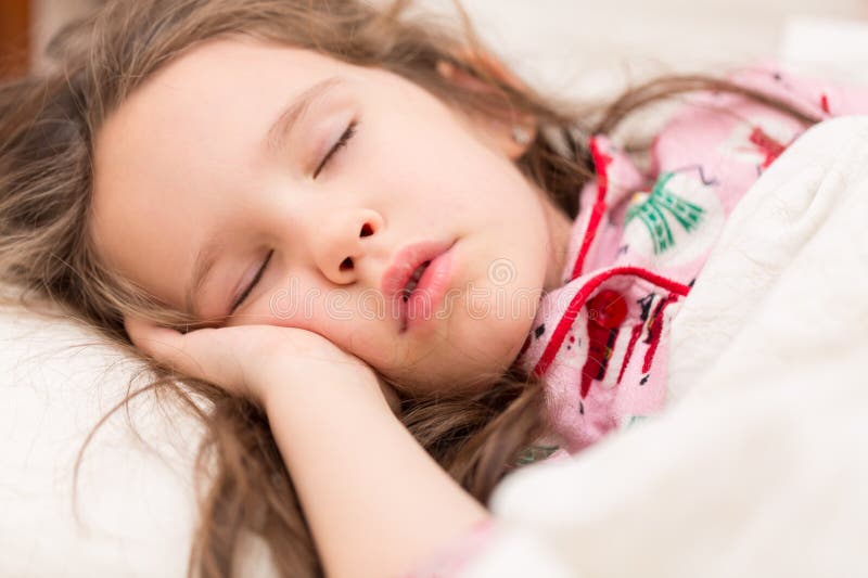 Portret uroczej, uroczej kaukaskiej dziewczynki śpiącej słodko w sypialni obraz stock