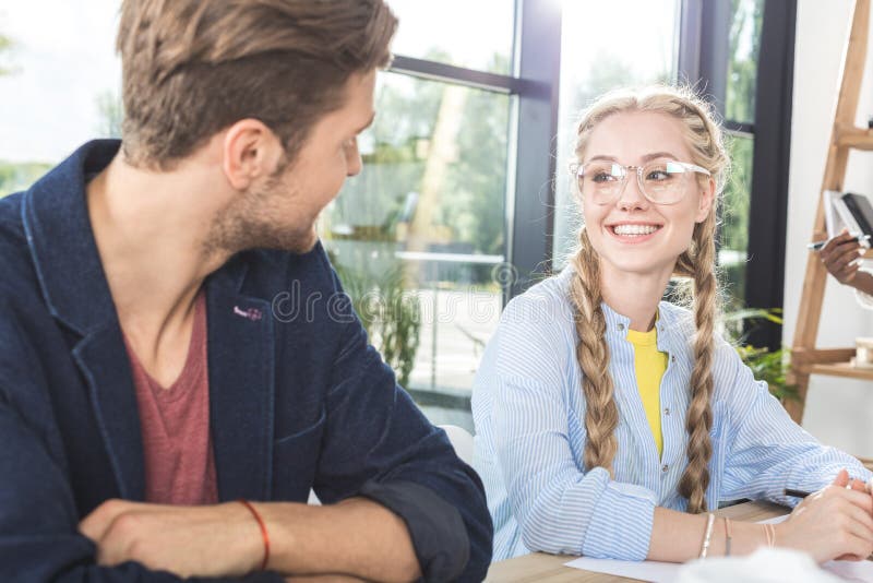 portret uśmiechnięci biznesowi koledzy ma rozmowę podczas gdy siedzący przy stołem fotografia stock portret uśmiechnięci biznesowi koledzy ma rozmowę podczas gdy siedzący przy stołem fotografia stock