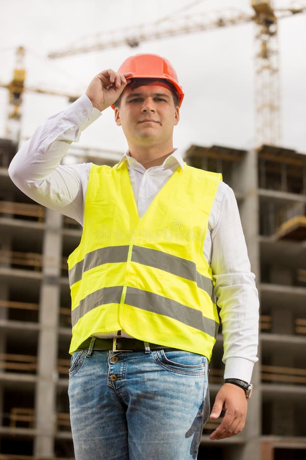 Portret uśmiechnięty inżynier w hardhat pozuje przeciw pracować c zdjęcia stock