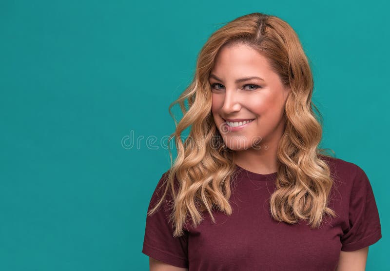 Portret van blonde glimlachende vrouw op een blauwe achtergrond stock afbeeldingen Portret van blonde glimlachende vrouw op een blauwe achtergrond stock afbeeldingen