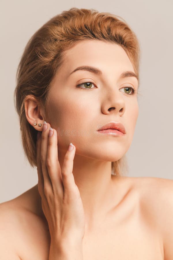 Portret van blonde vrouwen met groene ogen en kort haar Hij raakt zijn gezicht met zijn handen, een zachte aanraking In een stock foto's Portret van blonde vrouwen met groene ogen en kort haar Hij raakt zijn gezicht met zijn handen, een zachte aanraking In een stock foto's