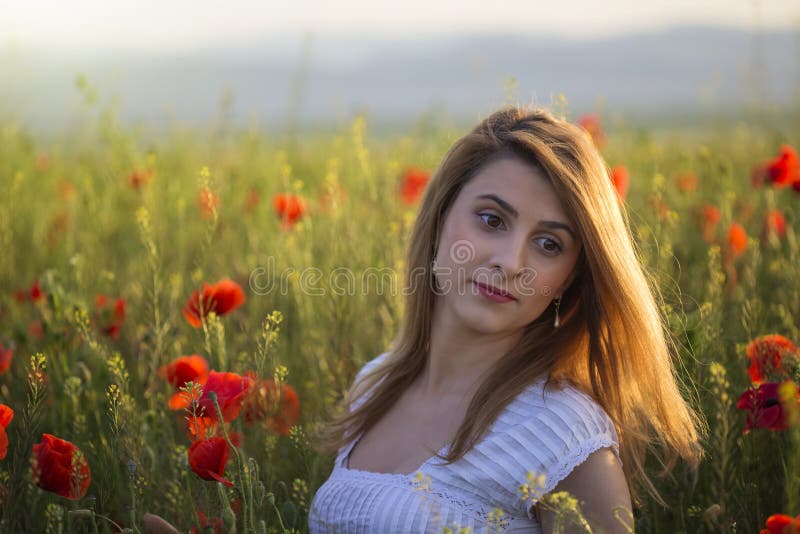 Portret van blondevrouw op gebied van papavers stock afbeeldingen