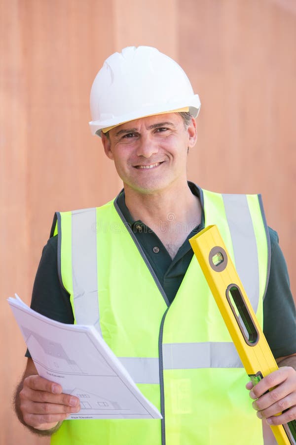 Portret van Bouwvakker On Building Site met Huisplan stock foto Portret van Bouwvakker On Building Site met Huisplan stock foto