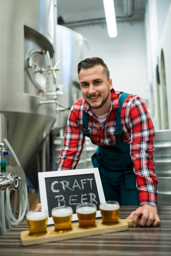 Portret van brouwer met vier glazen ambachtbier op lijst royalty-vrije stock foto Portret van brouwer met vier glazen ambachtbier op lijst royalty-vrije stock foto