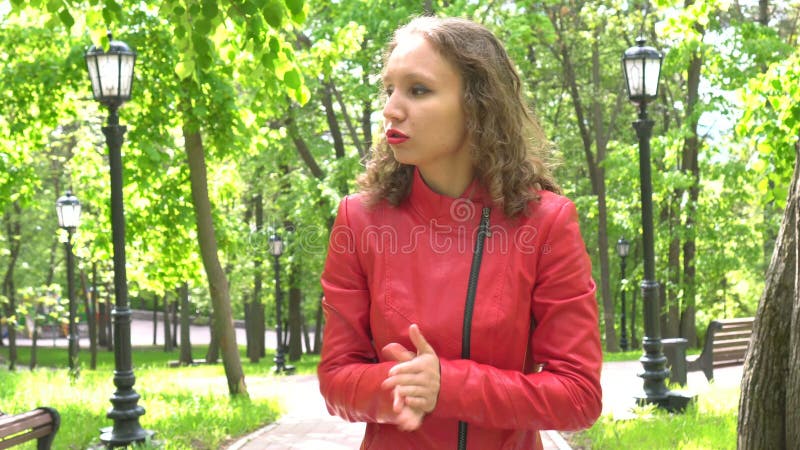 Portret van de aantrekkelijke jonge ongerust gemaakte vrouw in rood leerjasje