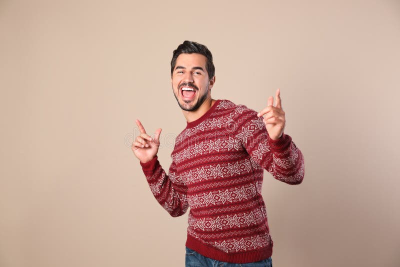 Portret van de gelukkige mens in Kerstmissweater op beige stock fotografie Portret van de gelukkige mens in Kerstmissweater op beige stock fotografie