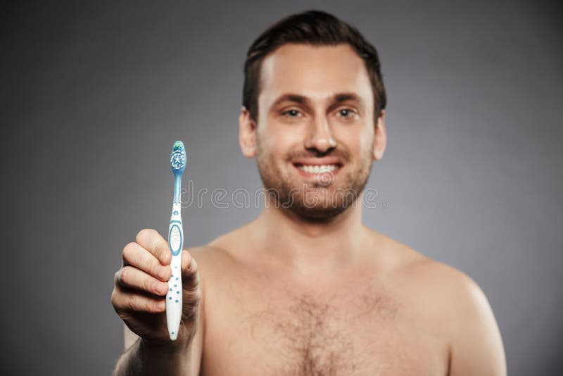 Portret van de glimlachende halve naakte mens met varkenshaar die toothbru tonen stock afbeeldingen Portret van de glimlachende halve naakte mens met varkenshaar die toothbru tonen stock afbeeldingen