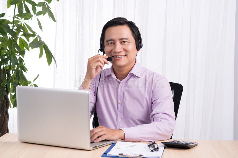 Portret van de knappe Aziatische adviseur die van de hotlinepersoon hea dragen