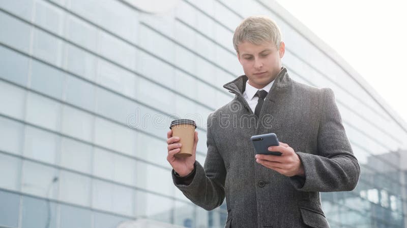 Portret van de knappe bedrijfsmens die smartphone en het drinken gebruiken royalty-vrije stock afbeelding Portret van de knappe bedrijfsmens die smartphone en het drinken gebruiken royalty-vrije stock afbeelding
