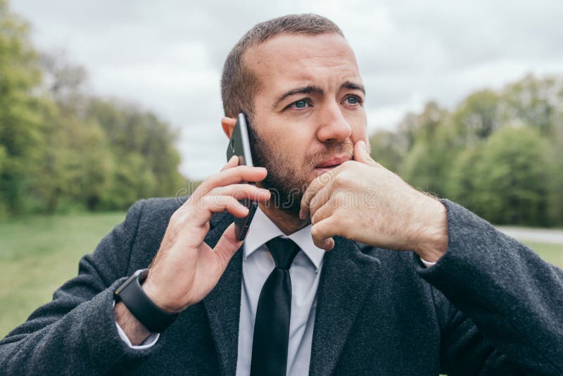 Portret van de knappe jonge stedelijke Europese professionele mens die mobiel gadget in openlucht gebruiken royalty-vrije stock foto's Portret van de knappe jonge stedelijke Europese professionele mens die mobiel gadget in openlucht gebruiken royalty-vrije stock foto's