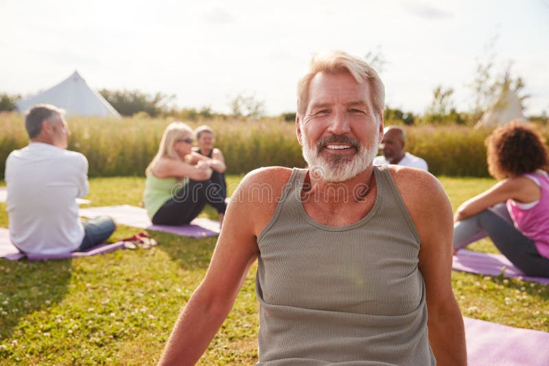 Portret van de mens op de buitenzijde van Yoga retreat met vrienden en kampeerterrein op de achtergrond