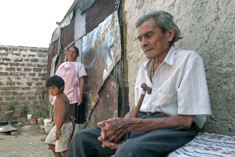 Argentina, captal, city Buenos Aires: closeup in daily life of a senior at home in slum 24, Villa Baracas. In the background are his wife and granchild, grandson. Fot medical care this poor people do not have money. This old, sickly, unhealthy, man receives no pension and can not afford his medicine. For his house and food he is dependent on his daughters. He is stting sad, beaten down, apathetic. Argentina, captal, city Buenos Aires: closeup in daily life of a senior at home in slum 24, Villa Baracas. In the background are his wife and granchild, grandson. Fot medical care this poor people do not have money. This old, sickly, unhealthy, man receives no pension and can not afford his medicine. For his house and food he is dependent on his daughters. He is stting sad, beaten down, apathetic