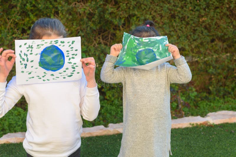 Portret van de twee leuke meisjes die de bol van de tekeningsaarde houden Jonge geitjes paintig beeld van aarde die pret hebben o stock fotografie Portret van de twee leuke meisjes die de bol van de tekeningsaarde houden Jonge geitjes paintig beeld van aarde die pret hebben o stock fotografie
