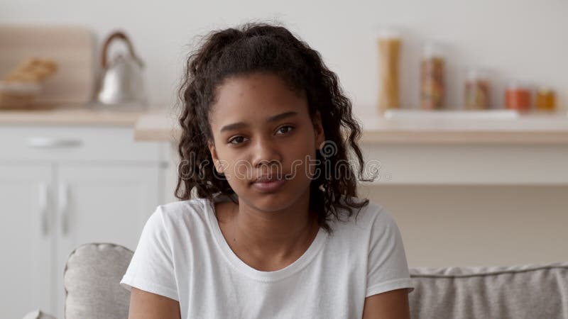 Portret van droevig afrikaans - amerikaans meisje met camera