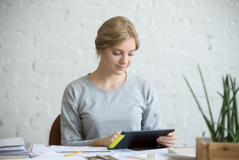 Portret van een aantrekkelijke vrouw met een tablet bij bureau royalty-vrije stock afbeeldingen Portret van een aantrekkelijke vrouw met een tablet bij bureau royalty-vrije stock afbeeldingen