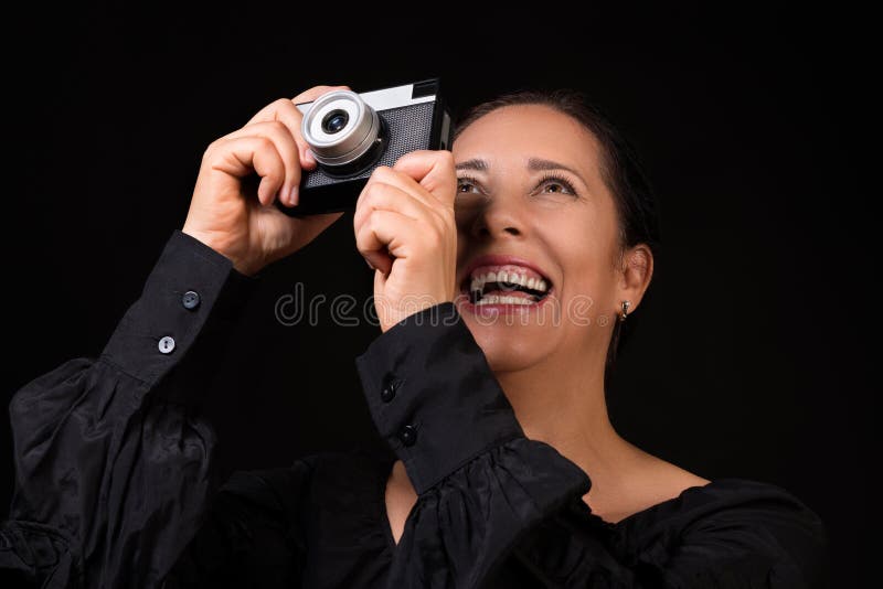 portret van een gelukkige glimlachende vrouw die foto op een retro camera over zwarte achtergrond nemen royalty-vrije stock fotografie portret van een gelukkige glimlachende vrouw die foto op een retro camera over zwarte achtergrond nemen royalty-vrije stock fotografie