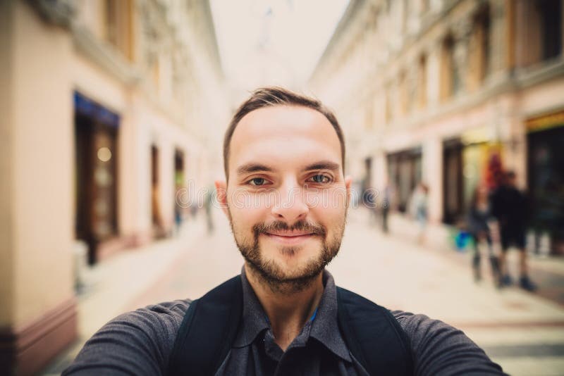 Portret van een gelukkige mens met baard die selfie nemen De glimlachen van de Hipstertoerist in de camera Vage achtergrond royalty-vrije stock foto Portret van een gelukkige mens met baard die selfie nemen De glimlachen van de Hipstertoerist in de camera Vage achtergrond royalty-vrije stock foto