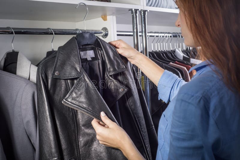 Portret Van Een Gerasterd Meisje in Een Kleding Voor Vrouwen in Een Winkel - Pak Winkel Kiest Een Leren Jasje Stock Afbeelding Image of volwassen, zaken: 179326859