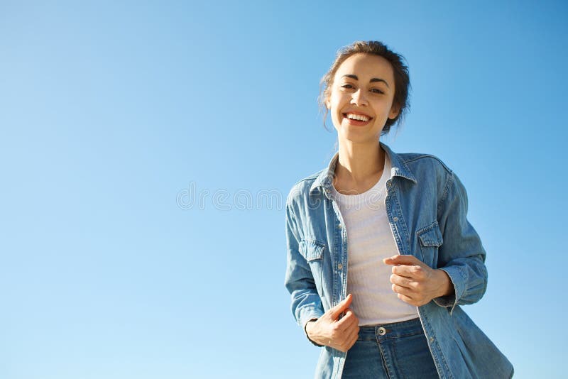 Portret van een jonge aantrekkelijke vrouw op de blauwe hemelachtergrond stock foto's Portret van een jonge aantrekkelijke vrouw op de blauwe hemelachtergrond stock foto's
