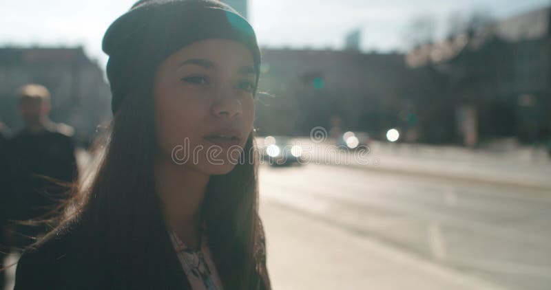 Portret van een jonge Afrikaanse Amerikaanse vrouw die op een taxi of een bus wachten, in openlucht