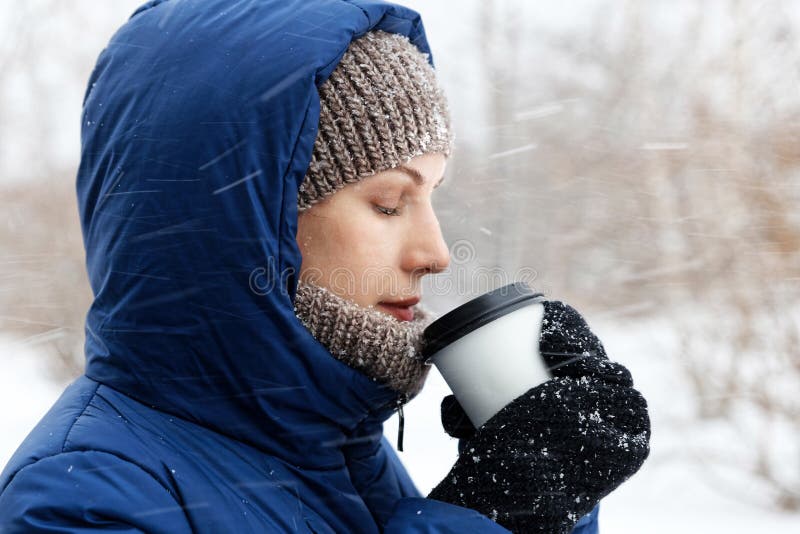Portret van een jonge die vrouw door vliegende sneeuwvlokken wordt omringd stock foto Portret van een jonge die vrouw door vliegende sneeuwvlokken wordt omringd stock foto