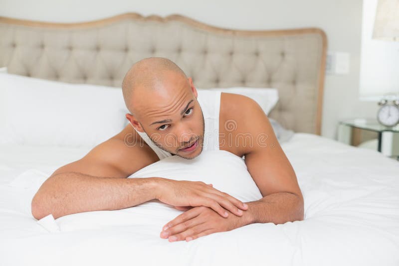 Portret van een jonge mens die in bed rusten stock afbeelding Portret van een jonge mens die in bed rusten stock afbeelding