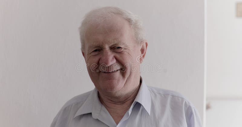 Portret van een knappe seniorman die met camera lacht op achtergrond