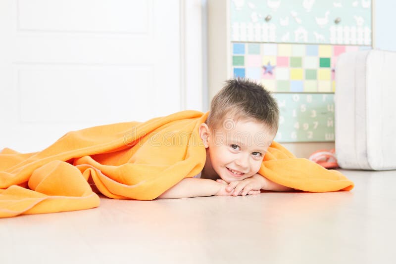 Portret van een leuke baby in oranje plaid in huis stock afbeelding Portret van een leuke baby in oranje plaid in huis stock afbeelding
