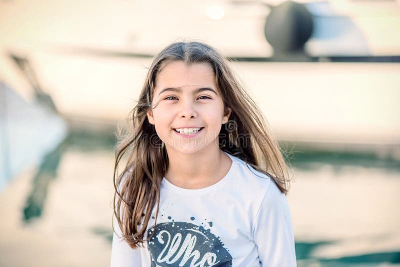 Portret van een mooi gelukkig meisje die en de camera glimlachen bekijken stock foto Portret van een mooi gelukkig meisje die en de camera glimlachen bekijken stock foto