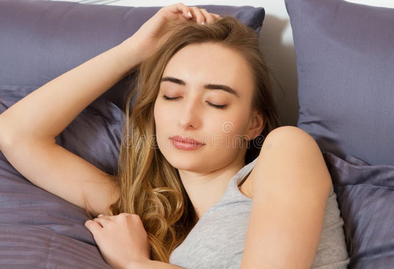 Portret van een mooi glimlachmeisje met gesloten ogen op het bed na slaap royalty-vrije stock afbeeldingen Portret van een mooi glimlachmeisje met gesloten ogen op het bed na slaap royalty-vrije stock afbeeldingen