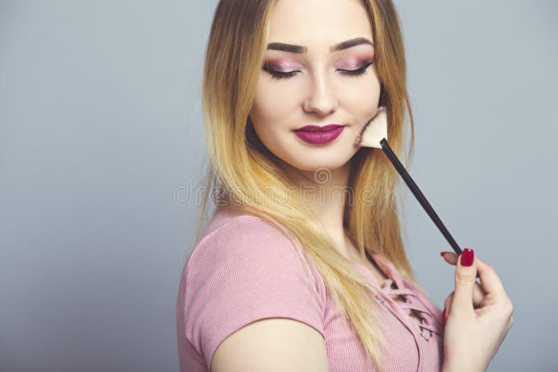 portret van een mooi meisje met make-upborstel in een studio, een vrouwengezicht, schoonheidsmiddelen en natuurlijk schoonheidsco stock foto's portret van een mooi meisje met make-upborstel in een studio, een vrouwengezicht, schoonheidsmiddelen en natuurlijk schoonheidsco stock foto's