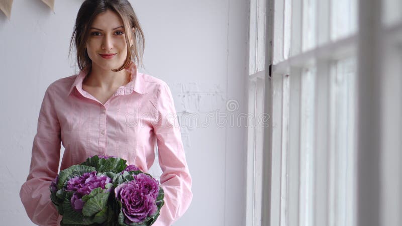 Portret van een mooie bloemist met een violet boeket van ongebruikelijke bloemen - brassica kijk in de camera stock afbeeldingen Portret van een mooie bloemist met een violet boeket van ongebruikelijke bloemen - brassica kijk in de camera stock afbeeldingen