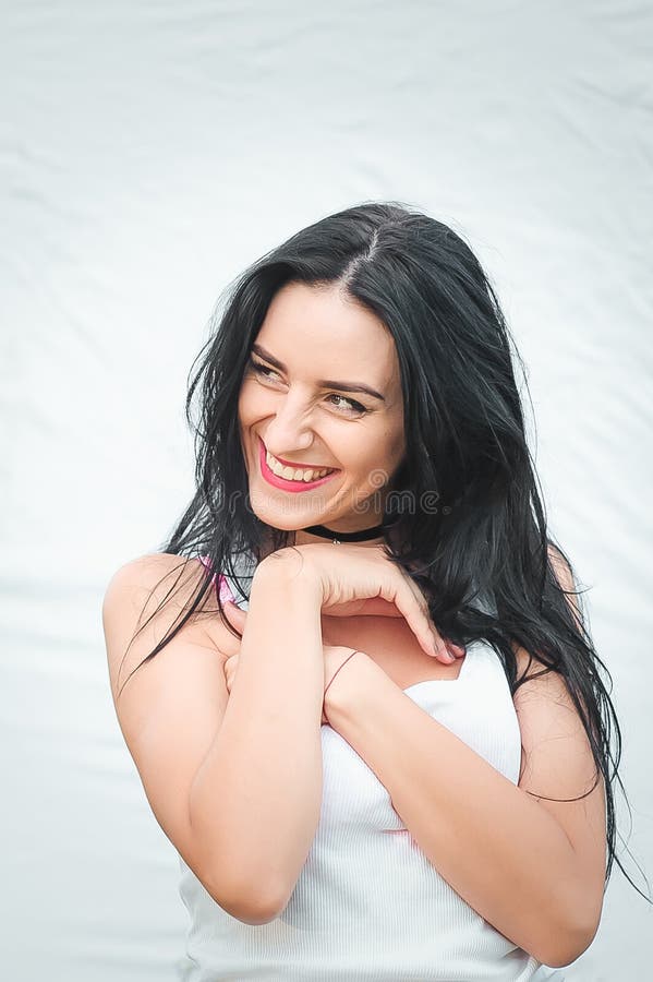 Portret van een mooie jonge vrouw in een wit T-shirt met zwart haar vreugde en lachen degenereren positieve emoties Levensstijl stock afbeeldingen Portret van een mooie jonge vrouw in een wit T-shirt met zwart haar vreugde en lachen degenereren positieve emoties Levensstijl stock afbeeldingen