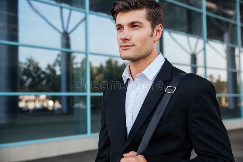 Portret van een peinzende zakenman die zich in openlucht dichtbij de bureaubouw bevinden royalty-vrije stock fotografie Portret van een peinzende zakenman die zich in openlucht dichtbij de bureaubouw bevinden royalty-vrije stock fotografie