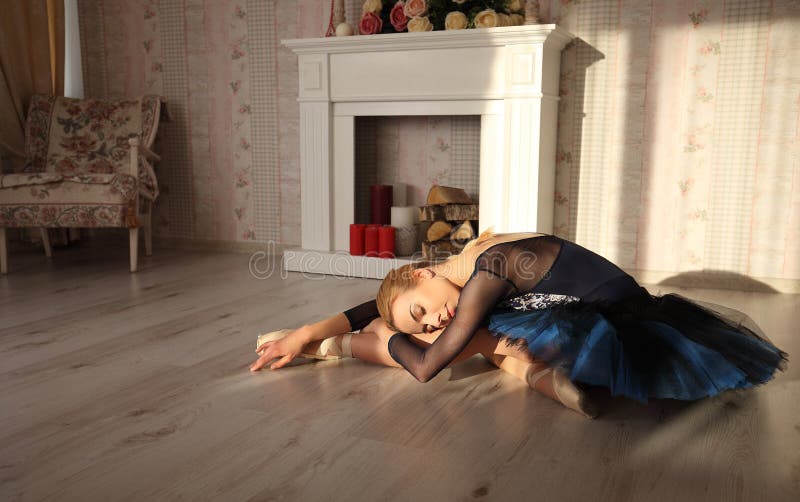 Portret van een professionele balletdanserzitting op de houten vloer in zonlicht Balletconcept stock foto Portret van een professionele balletdanserzitting op de houten vloer in zonlicht Balletconcept stock foto